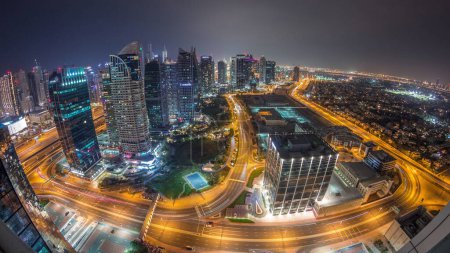 Foto de Jumeirah Lake Towers barrio residencial timelapse noche aérea cerca de Dubai Marina. Rascacielos modernos iluminados y tráfico desde arriba - Imagen libre de derechos