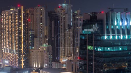 Foto de Vista desde la azotea del increíble puerto deportivo de Dubái y el timelapse nocturno aéreo de los rascacielos JLT, Dubái, Emiratos Árabes Unidos. Torres iluminadas desde arriba - Imagen libre de derechos