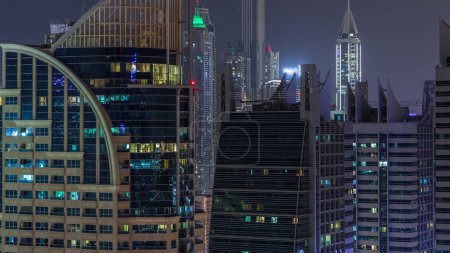 Téléchargez les photos : Jumeirah Lake Towers quartier résidentiel nuit aérienne timelapse près de Dubai Marina. Des gratte-ciels modernes éclairés et le trafic d'en haut - en image libre de droit