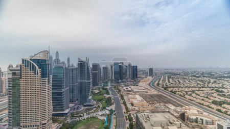 Foto de Jumeirah Lake Towers barrio residencial timelapse aéreo cerca de Dubai Marina. Rascacielos modernos y parque desde arriba - Imagen libre de derechos
