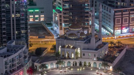 Téléchargez les photos : Architecture résidentielle moderne du port de plaisance de Dubaï et de la mosquée Mohammed Bin Ahmed Almulla nuit aérienne au jour le jour transition timelapse, Émirats arabes unis. Promenade et circulation sur une route - en image libre de droit
