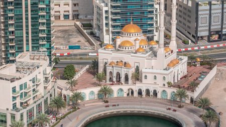 Modern residential architecture of Dubai Marina and Mohammed Bin Ahmed Almulla Mosque aerial timelapse, United Arab Emirates. Promenade and traffic on a road