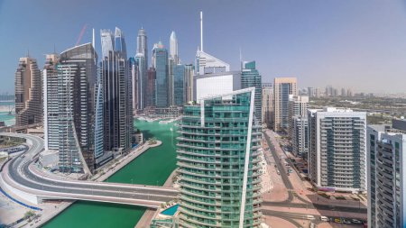 Foto de Vista panorámica aérea de Dubai Marina rascacielos residenciales y de oficinas con frente al mar, mezquita y puente timelapse. Barcos y yates flotantes - Imagen libre de derechos