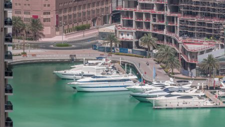 Photo for Waterfront promenade in Dubai Marina aerial timelapse. Boats and yachts floating on canal. Dubai, United Arab Emirates - Royalty Free Image