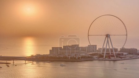 Téléchargez les photos : Coucher de soleil sur l'île Bluewaters à Dubaï timelapse aérienne. Île artificielle à usage mixte située au large de la côte de Jumeirah Beach Residence - en image libre de droit