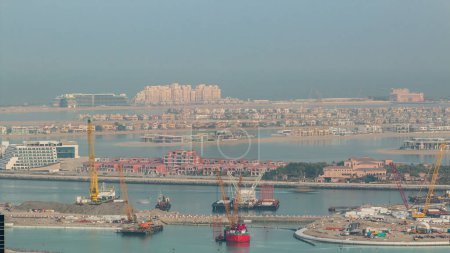 Photo for Aerial view of Palm Jumeirah Island timelapse. Morning top view with villas, hotels and yachts. Construction process of new cruise terminal - Royalty Free Image