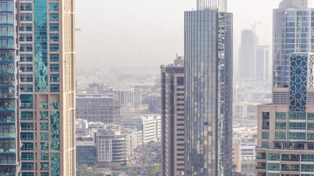 Téléchargez les photos : Vue aérienne d'une intersection routière dans une grande ville timelapse. Paysage urbain de Dubai Marina et quartier de la ville des médias aux EAU avec voitures et tramway - en image libre de droit
