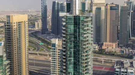 Aerial top view of Dubai Marina and JLT evening timelapse. Skyscrapers before sunset in Dubai, UAE. Modern towers and traffic on the road
