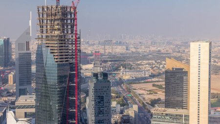 Vista panorámica de los edificios de Sheikh Zayed Road y el timelapse aéreo DIFC en Dubai, Emiratos Árabes Unidos. Modernas torres y rascacielos con obras de construcción en el centro financiero y el centro de la ciudad
