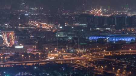 Foto de Vista aérea del barrio de Deira y Dubai arroyo con edificios típicos antiguos y modernos timelapse noche. Tráfico en la intersección. Vista desde la azotea del rascacielos. Dubai, Emiratos Árabes Unidos - Imagen libre de derechos