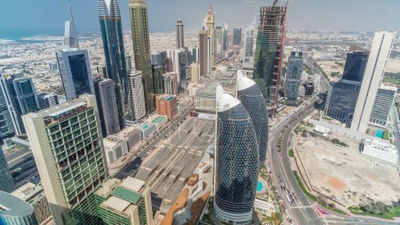 Vista del horizonte de los edificios de Sheikh Zayed Road y el timelapse aéreo DIFC durante todo el día con sombras en movimiento en Dubai, Emiratos Árabes Unidos. Modernas torres y rascacielos en el centro financiero y el centro
