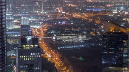 Foto de Vista aérea al distrito financiero y zabeel noche timelapse con el tráfico y en construcción edificio con grúas del centro de Dubai. Deira en un segundo plano. Rascacielos iluminados - Imagen libre de derechos