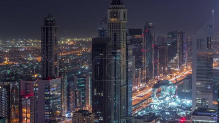 Photo for Skyline of the buildings near Sheikh Zayed Road and DIFC aerial night to day transition in Dubai, UAE. Modern towers and illuminated skyscrapers in financial center and downtown before sunrise - Royalty Free Image