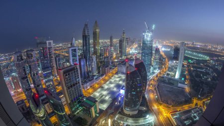 Téléchargez les photos : Skyline des bâtiments près de Sheikh Zayed Road et DIFC transition aérienne de nuit à jour à Dubaï, EAU. Tours modernes et gratte-ciel éclairés dans le centre financier et le centre-ville avant le lever du soleil - en image libre de droit