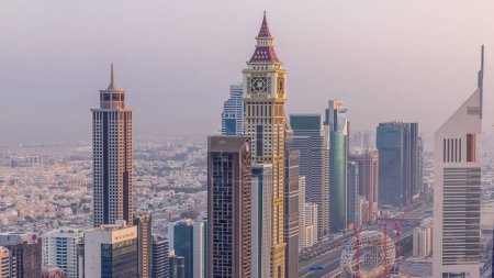 Vista del horizonte de los edificios de Sheikh Zayed Road y el timelapse aéreo DIFC durante el amanecer en Dubai, Emiratos Árabes Unidos. Modernas torres y rascacielos en el centro financiero y el centro
