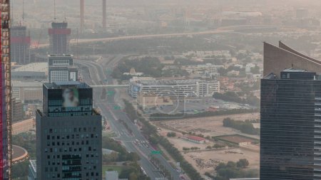 Foto de Vista aérea al timelapse financiero y del distrito de Zabeel durante el amanecer con el tráfico y en construcción edificio con grúas del centro de Dubai. La neblina de la mañana. Deira sobre un fondo - Imagen libre de derechos