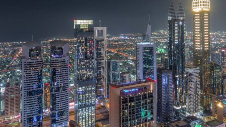 Téléchargez les photos : Skyline panoramique des bâtiments près de Sheikh Zayed Road et de l'espace aérien de nuit DIFC à Dubaï, Émirats arabes unis. Tours modernes et gratte-ciel éclairés dans le centre financier et le centre-ville - en image libre de droit