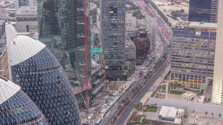 Téléchargez les photos : Skyline des bâtiments près de Sheikh Zayed Road et DIFC de jour comme de nuit à Dubaï, EAU. Tours et gratte-ciel modernes avec la circulation sur la route dans le centre financier et le centre-ville après le coucher du soleil - en image libre de droit