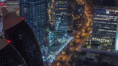 Téléchargez les photos : Skyline des bâtiments près de Sheikh Zayed Road et DIFC timelapse de nuit aérienne à Dubaï, EAU. Tours modernes et gratte-ciel éclairés dans le centre financier et le centre-ville - en image libre de droit