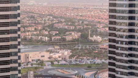 Foto de Vista aérea de casas de apartamentos y villas entre altas torres en Dubai ciudad timelapse cerca de jumeirah lago torres distrito, Emiratos Árabes Unidos. Vista superior desde rascacielos - Imagen libre de derechos