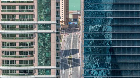 Foto de Edificios residenciales y de oficinas en Jumeirah lago torres distrito mañana timelapse con en Dubai. Vista panorámica aérea desde arriba con tráfico en una carretera entre rascacielos modernos - Imagen libre de derechos