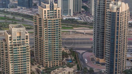 Foto de Dubai Marina rascacielos y torres de lago jumeirah vista desde el timelapse aéreo superior en los Emiratos Árabes Unidos. Tráfico en una carretera - Imagen libre de derechos