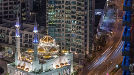 Téléchargez les photos : Architecture résidentielle moderne de Dubai Marina et Mohammed Bin Ahmed Almulla Mosquée timelapse de nuit aérienne, Émirats arabes unis. Trafic sur une route - en image libre de droit