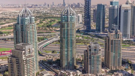 Foto de Dubai Marina rascacielos y torres de lago jumeirah vista desde el timelapse aéreo superior en los Emiratos Árabes Unidos. Tráfico en una carretera - Imagen libre de derechos