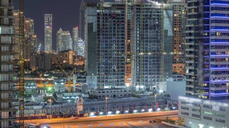 Téléchargez les photos : Vue aérienne d'un gratte-ciel en construction avec grues la nuit timelapse. Centre-ville sur fond de Business Bay, Dubai, Émirats arabes unis
. - en image libre de droit