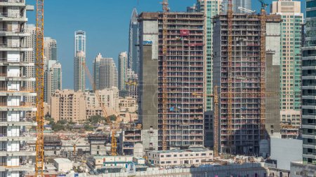 Photo for Modern construction with special machines and cranes aerial timelapse with blue and clear sky in Business Bay with Downtown on a background, Dubai, United Arab Emirates - Royalty Free Image