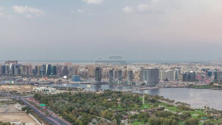 Foto de Vista panorámica de las luces desde carreteras iluminadas y ventanas de rascacielos transición día a noche Timelapse Aerial en Dubai Creek y Deira, Emiratos Árabes Unidos - Imagen libre de derechos