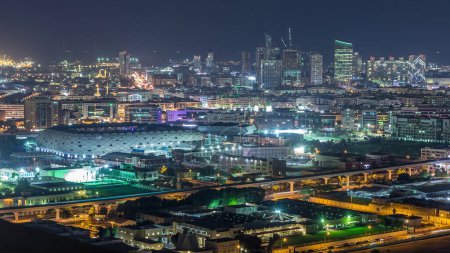 Téléchargez les photos : Belle vue sur les lumières vives des bâtiments de la ville et du stade avec un rythme rapide au timelapse aérien du soir dans le centre financier, Dubaï, Émirats arabes unis - en image libre de droit