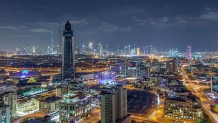 Photo for Nighttime Aerial view of lights from new modern buildings at evening with downtown skyscrapers and traffic on roads Timelapse, Dubai, United Arab Emirates - Royalty Free Image