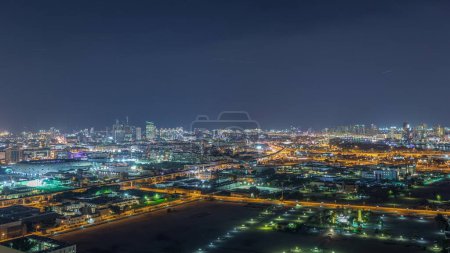 Photo for Panorama of the city at night with illuminated roads and beautiful buildings at night near river near Dubai creek aerial timelapse, United Arab Emirates - Royalty Free Image