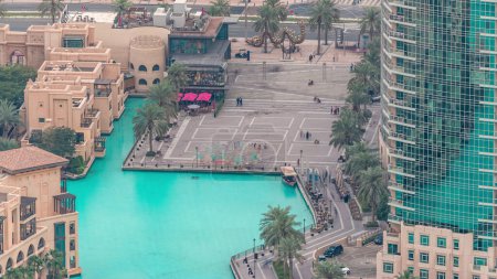 Foto de Dubai centro con fuentes zona cerca del centro comercial y timelapse zoco. Vista aérea a la isla del casco antiguo con plaza de burj desde arriba - Imagen libre de derechos