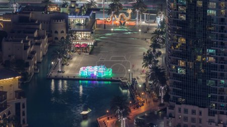 Foto de Dubai centro con fuentes zona cerca del centro comercial y la noche del zoco timelapse. Vista aérea a la isla del casco antiguo y la plaza del burj desde arriba - Imagen libre de derechos