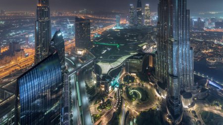 Téléchargez les photos : Vue panoramique sur l'horizon du centre-ville de Dubaï avec centre commercial, fontaines et Burj Khalifa nuit aérienne à la transition de jour timelapse. gratte-ciel modernes et ciel nuageux avant le lever du soleil - en image libre de droit