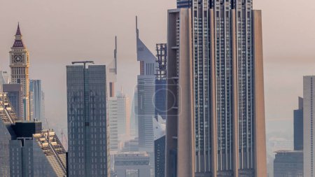 Foto de Dubai International Financial Centre distrito con rascacielos modernos timelapse temprano en la mañana con neblina. Vista aérea desde el centro con tráfico en las calles - Imagen libre de derechos