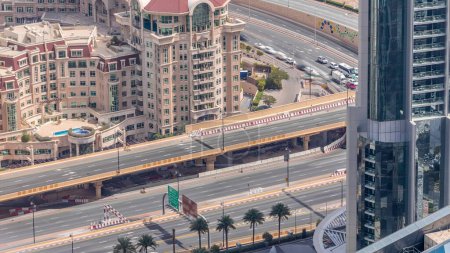 Téléchargez les photos : Vue aérienne de l'échangeur routier au centre-ville de Dubaï timelapse du soir. Al Saada Street et Financial Center Road. Paysages urbains pont de circulation. Routes et ruelles Crossroads, Dubaï, Émirats arabes unis - en image libre de droit