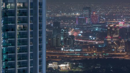 Téléchargez les photos : Vue aérienne du quartier Zabeel et Dubai Creek avec des bâtiments typiques anciens et modernes timelapse de nuit. Trafic à l'intersection. Vue depuis le toit du gratte-ciel. Dubai, Émirats arabes unis - en image libre de droit