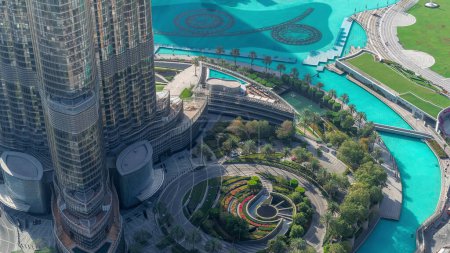 Téléchargez les photos : Dubaï centre-ville timelapse avec fontaine et circulation sur le cercle près de l'entrée du plus haut gratte-ciel, paysage urbain futuriste des Émirats arabes unis. Vue aérienne du dessus - en image libre de droit