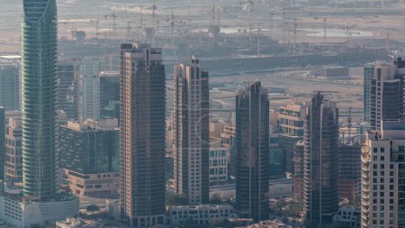 erstaunliche Luftaufnahme Dubais Wolkenkratzer in der Innenstadt im Zeitraffer mit Springbrunnen und Morgennebel, Dubai, vereinigte arabische Emirate. Moderne Türme und Großbaustelle mit vielen Kränen