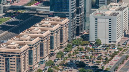 Téléchargez les photos : Vue aérienne du parking avec des arbres à l'extérieur des véhicules dans le centre-ville de Dubaï timelapse. Beaucoup de voitures près des maisons sur cheikh zayed route - en image libre de droit