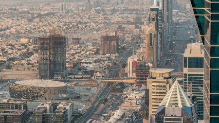 Téléchargez les photos : Des gratte-ciel sur Sheikh Zayed Road et DIFC Aerial Timelapse à Dubaï, Émirats Arabes Unis. Circulation sur une autoroute près du centre financier le soir avant le coucher du soleil depuis le toit de la baie d'affaires - en image libre de droit