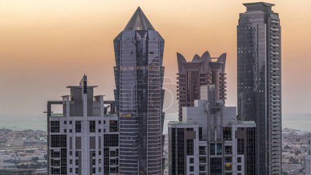 Foto de Vista aérea de rascacielos iluminados con luces desde ventanas. De día a noche, lapso de tiempo de transición en Business Bay, Dubai, Emiratos Árabes Unidos - Imagen libre de derechos