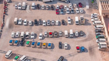 Photo for Aerial view full cars at large outdoor parking lots timelapse in Dubai, UAE. Office and recidential parking congestion and crowded parking lot with other cars try getting in and out, finding parking space. - Royalty Free Image