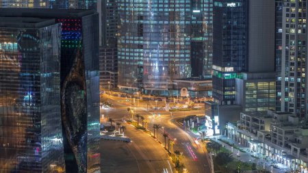Téléchargez les photos : Vue aérienne de la circulation urbaine sur un carrefour à Dubaï Chronométrage de nuit de la baie d'affaires. Carrefour routier d'en haut, circulation automobile et gratte-ciel autour - en image libre de droit