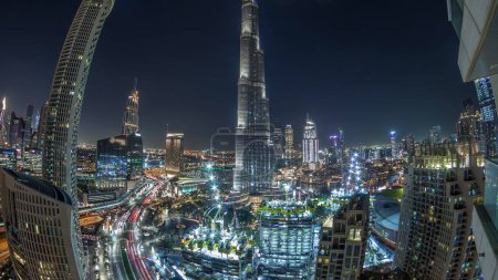 Foto de Vista panorámica del centro de Dubái con centro comercial, fuentes y timelapse nocturno aéreo Burj Khalifa. Rascacielos iluminados modernos y obras de construcción - Imagen libre de derechos