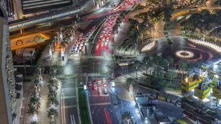 Foto de Vista aérea de la intersección con muchos transportes en el tráfico y callejón moderno a pie con timelapse noche fuente en el centro de Dubai, Dubai, Emiratos Árabes Unidos - Imagen libre de derechos