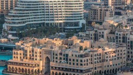Dubai Innenstadt mit Springbrunnen Bereich in der Nähe von Einkaufszentrum und Souk Zeitraffer. Luftaufnahme der Altstadtinsel von oben bei Sonnenuntergang